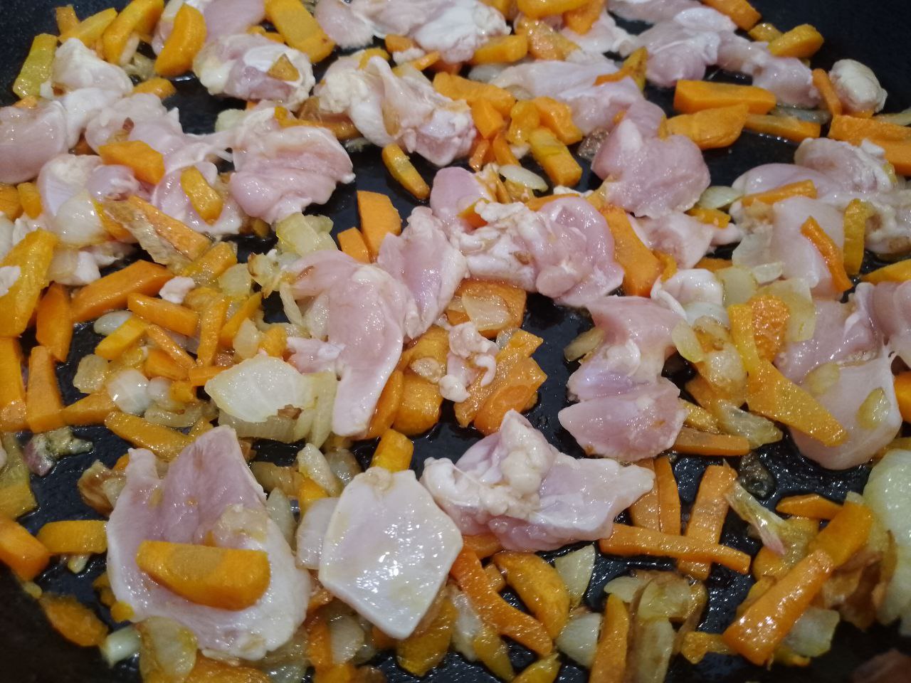 Тушеная спаржевая фасоль с овощами и куриным мясом: Добавляем кусочки мяса, перемешиваем и обжариваем медленном огне до полу готовности.