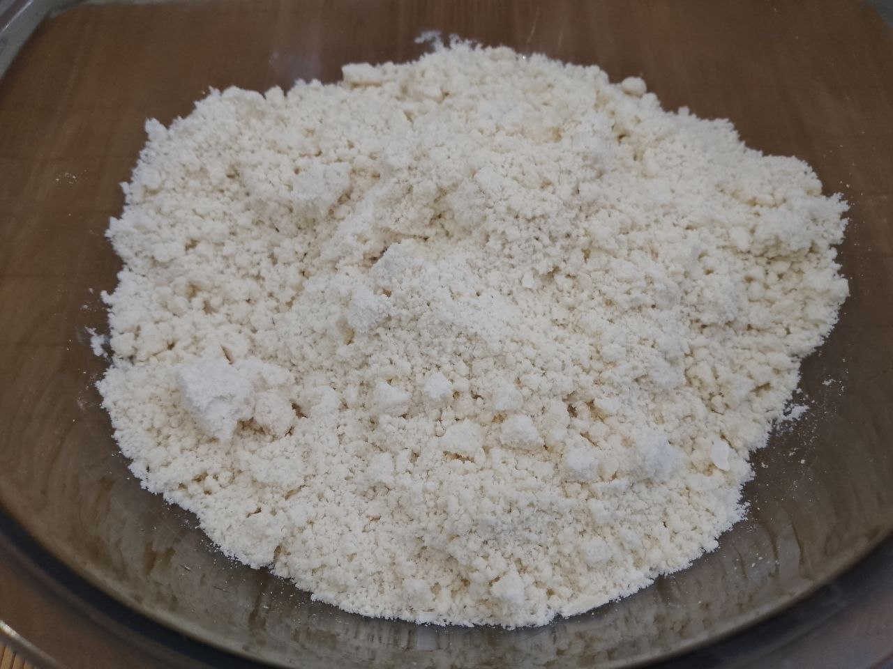 Домашнее печенье с кокосовой стружкой, песочное и рассыпчатое: В сухую смесь вливаем растительное масло и размягченное сливочное масло, растираем в мучную крошку.