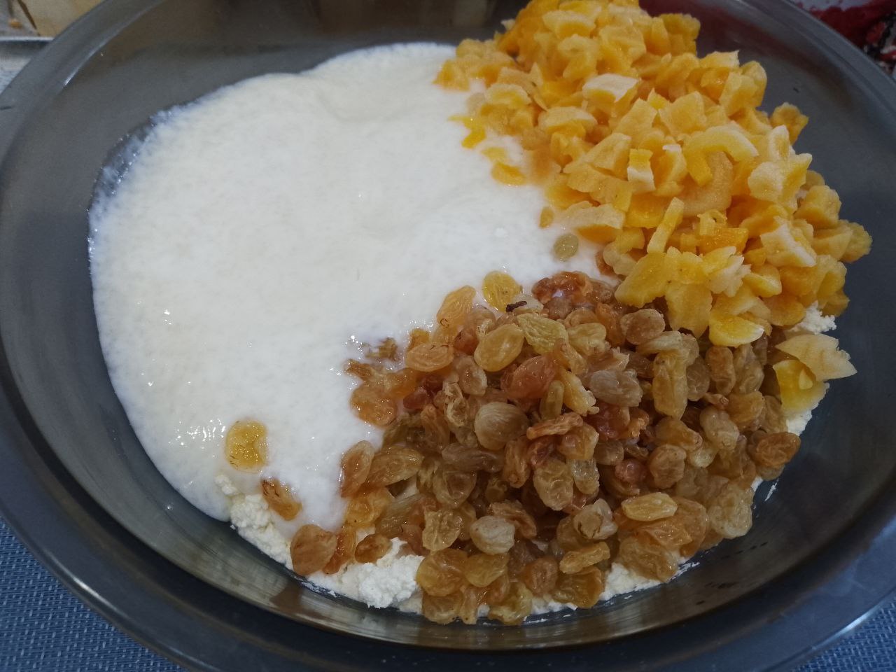Десерт из творога, изюма и кураги, нежный и вкусный: Соединяем творог со сметаной, добавляем курагу и изюм, тщательно перемешиваем.