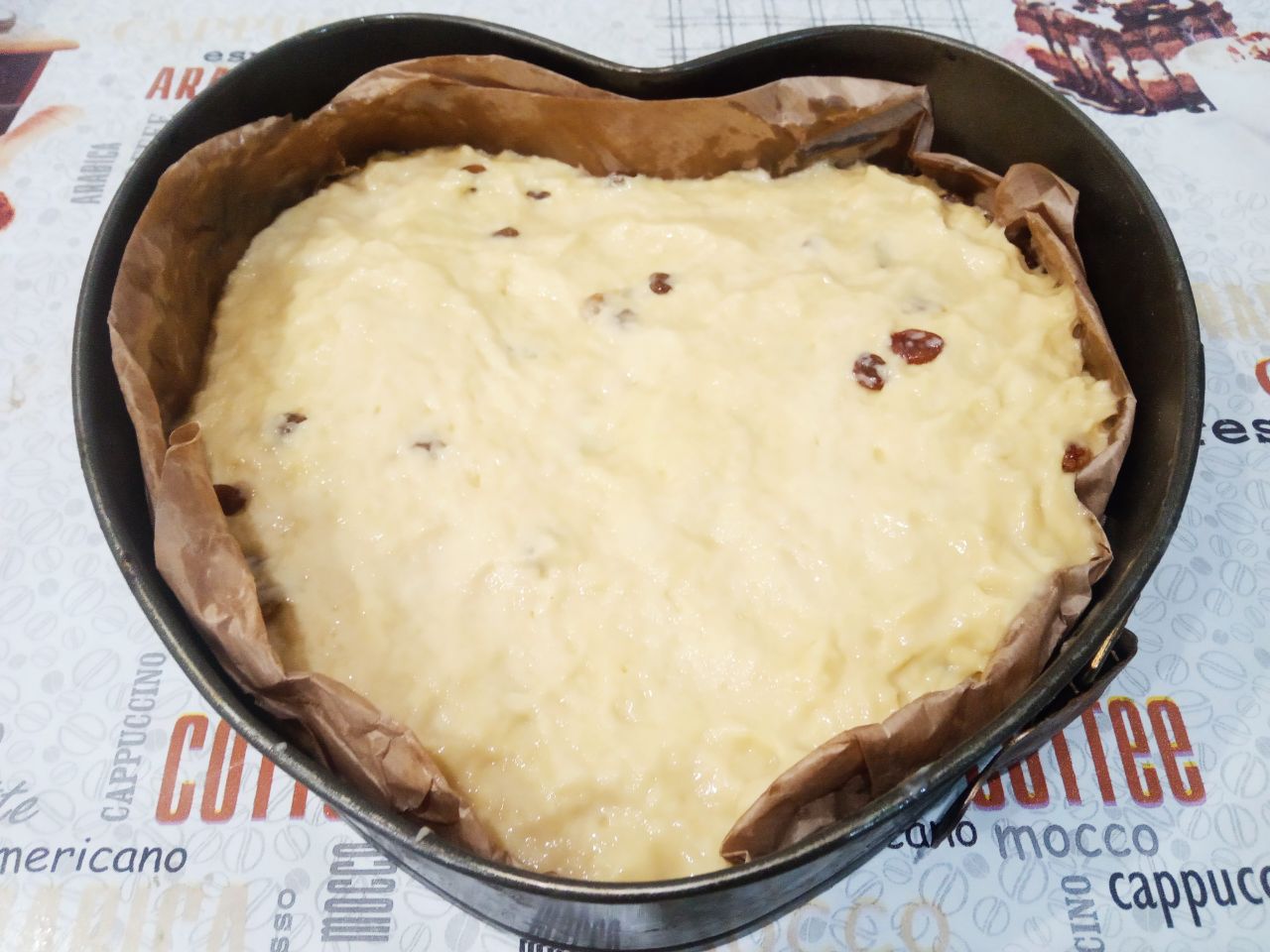Пирог сдобный из дрожжевого теста с изюмом и мёдом: Форму застилаем пергаментом и выкладываем тесто, сверху тесто разравниваем.