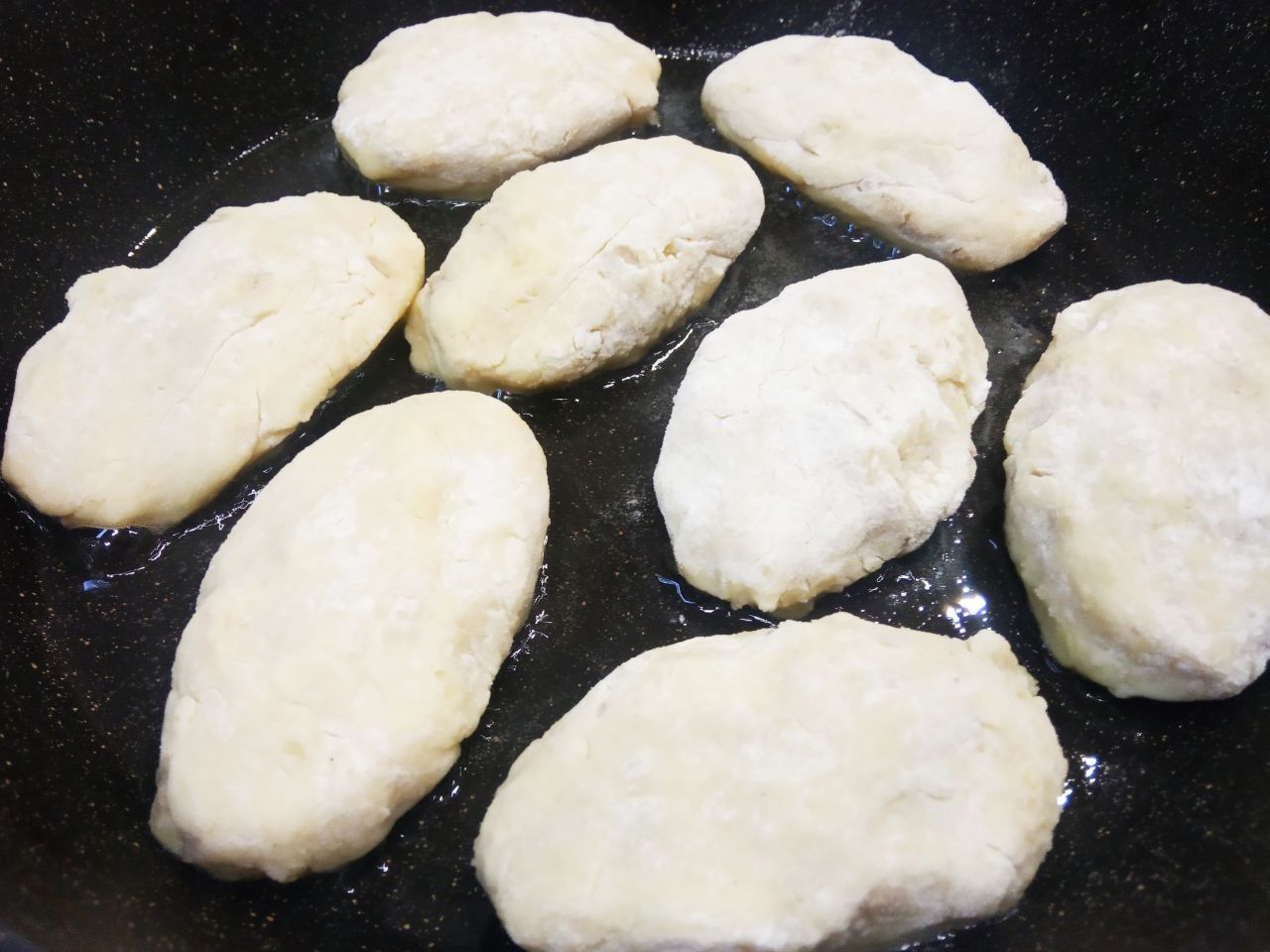 Картофельные пирожки с начинкой из куриного филе и лука: Разогреваем сковороду с растительным маслом и укладываем пирожки на сковороду.