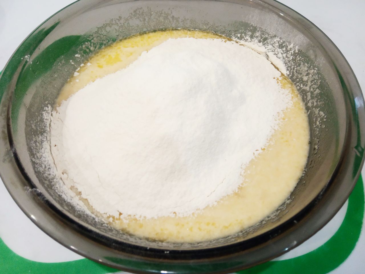Манный пирог на кефире, просто и вкусно: Муку просеиваем через сито и добавляем в смесь, размешиваем.