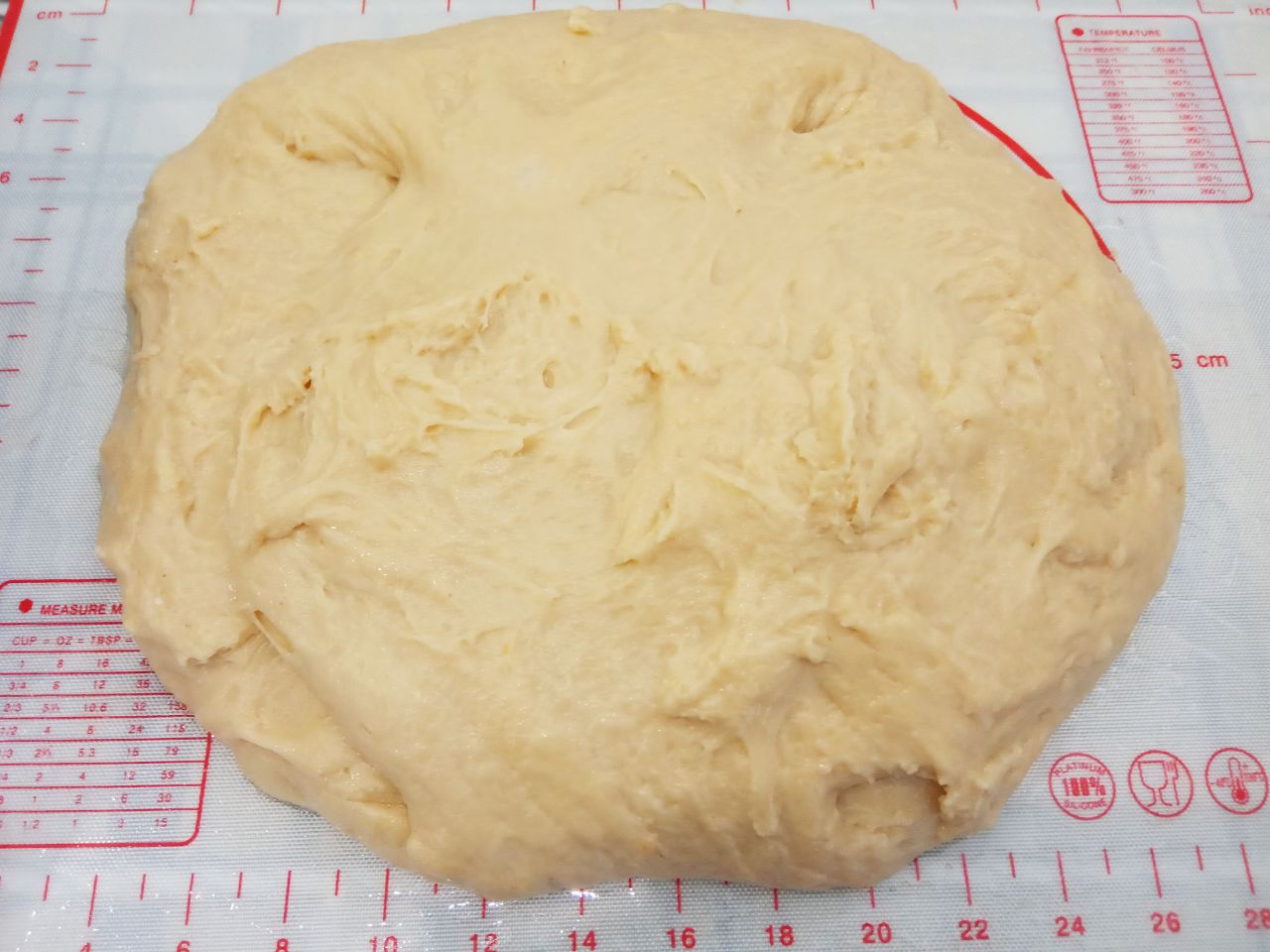 Домашние воздушные праздничные куличи: Муку добавляем частями, размешиваем сначала лопаткой, потом вымешиваем руками. Тесто перекладываем на рабочую