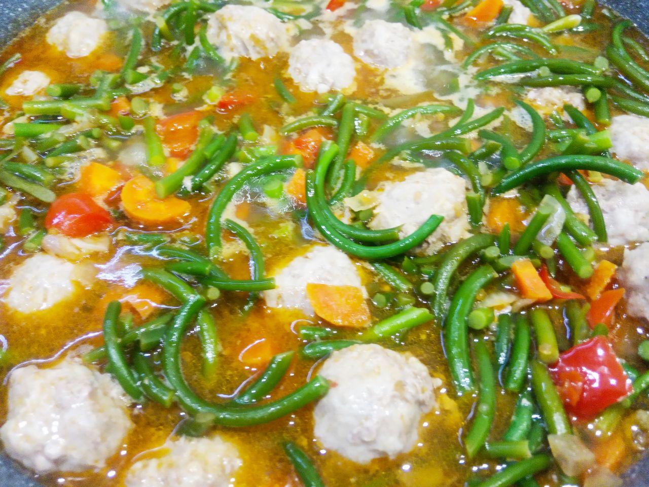 Чесночные стрелки с овощами, томатным соусом и мясным фаршем: Кладем к овощам чесночные стрелки, мясные шарики, соль и перец по вкусу, заливаем горячей кипяченой водой,