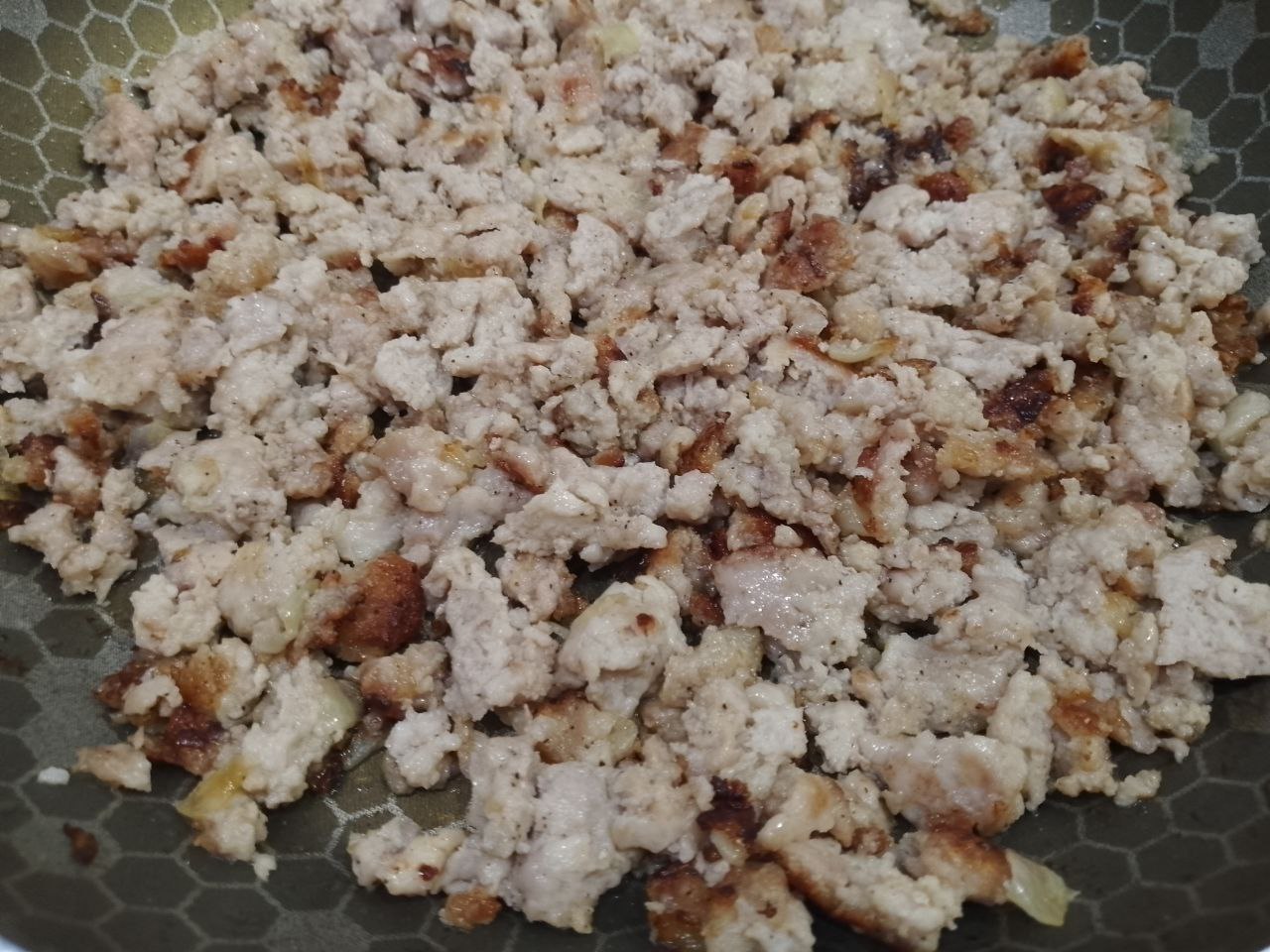 Рулет из тертого картофеля с мясной начинкой, запеченный в духовке: Добавляем фарш, солим, перчим и посыпаем чесноком, обжариваем до готовности.