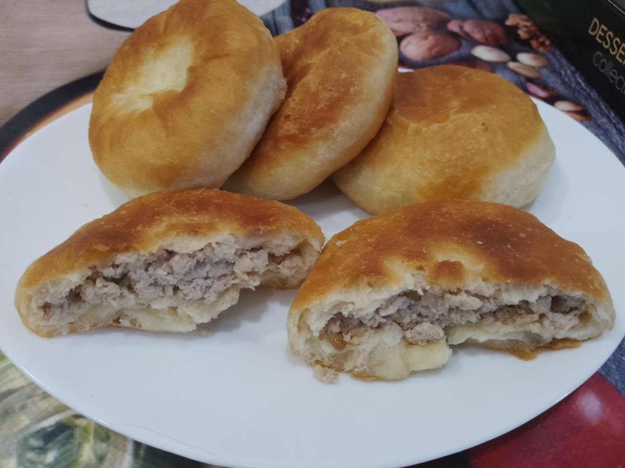 Пирожки из дрожжевого теста на сметане, с мясной начинкой, жареные на сковороде: Испеченные пирожки выкладываем на бумажное полотенце, чтобы убрать излишки жира. Потом пирожки складываем на