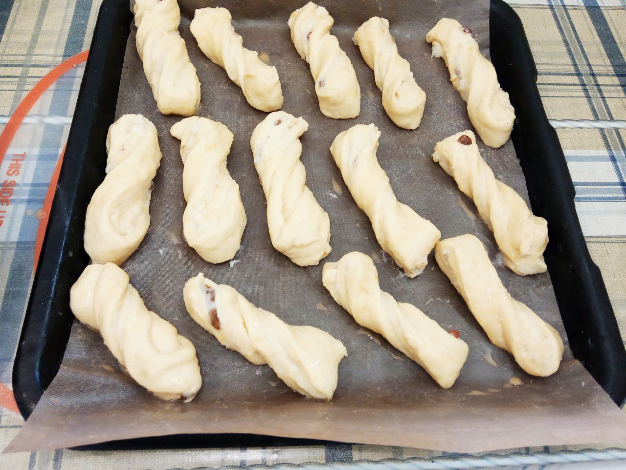 Воздушные и нежные булочки с заварным кремом и изюмом: Булочки оставляем на 20 минут для расстойки теста. Затем смазываем булочки взбитым яйцом.