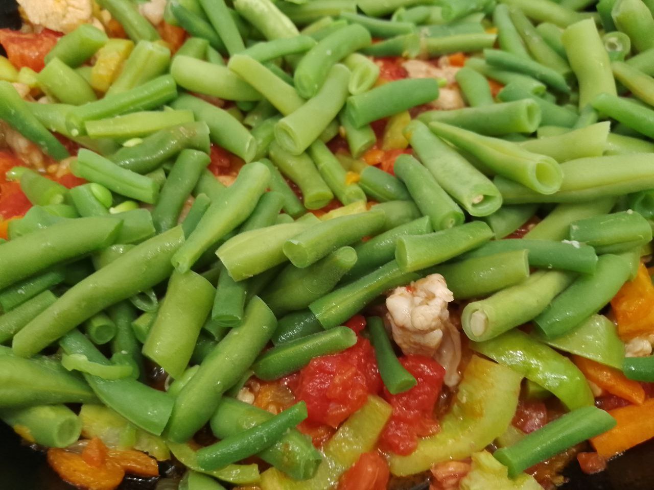 Тушеная спаржевая фасоль с овощами и куриным мясом: Кладем спаржевую фасоль, перемешиваем и тушим около 20 минут.