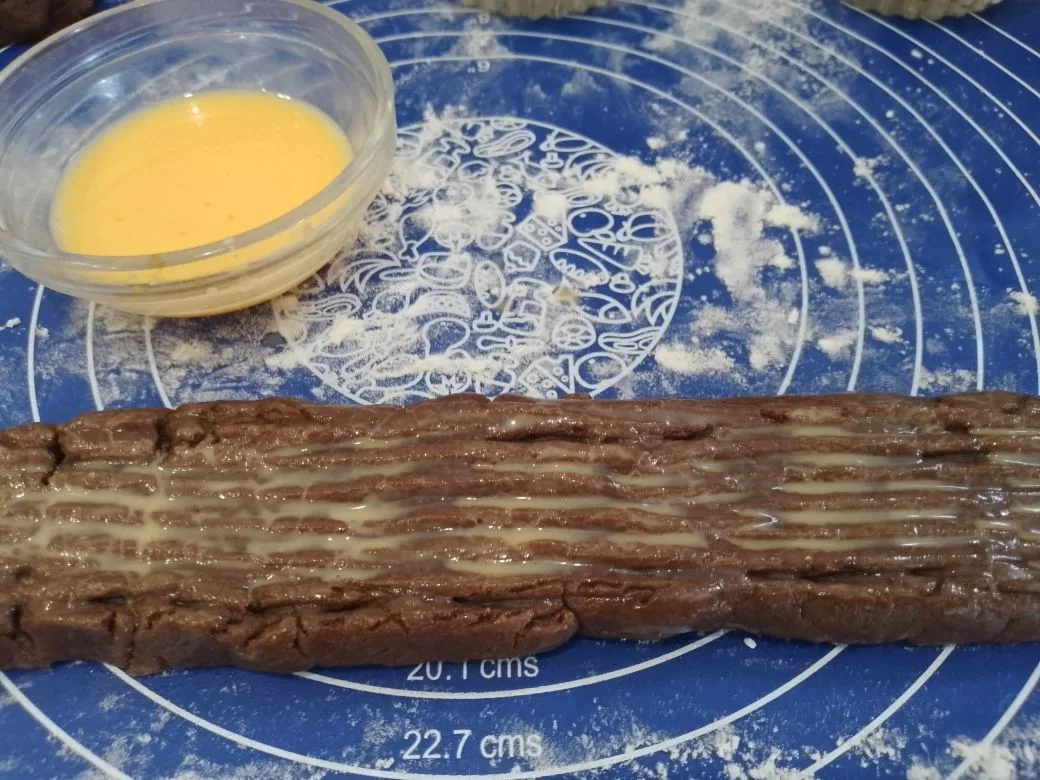 Шоколадное песочное печенье с кунжутом и кокосовой стружкой: Желток смешиваем с двумя чайными ложками молока, перемешиваем и смазываем валики.