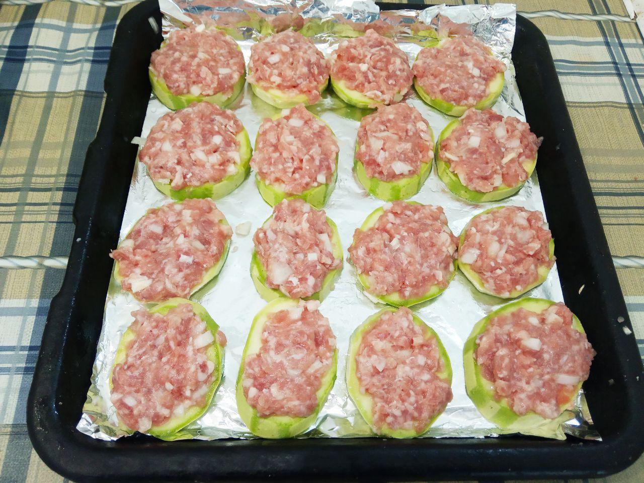 Вкусная закуска из кабачков с фаршем и сыром: На каждый кусочек накладываем фарш, равномерно разравниваем, поверх смазываем майонезом и кладем на противень.