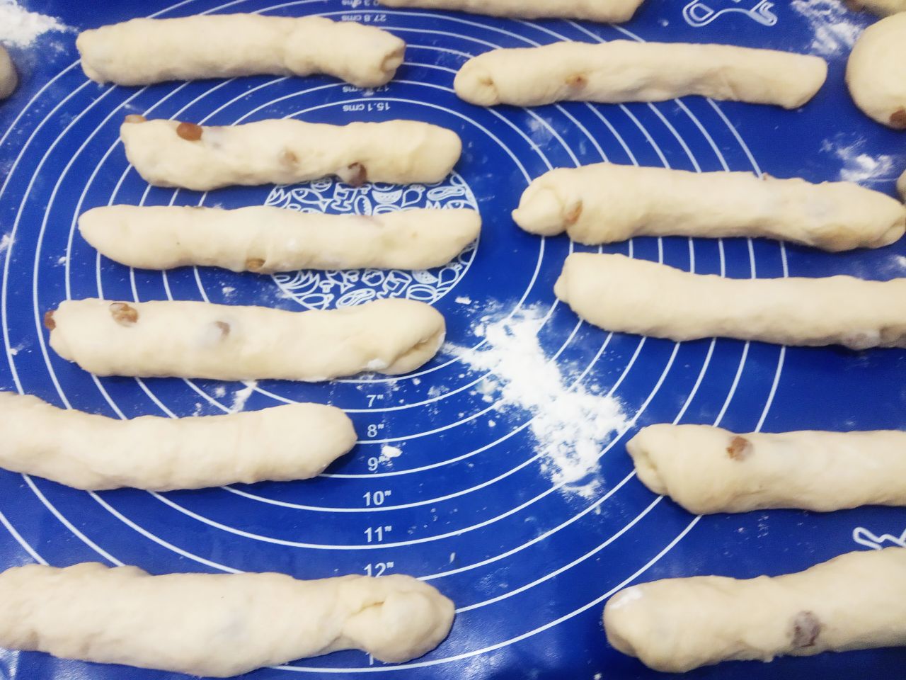 Булочки с начинкой из жареных яблок, изюма и корицы: Колобки для булочек с изюмом, раскатываем продолговатыми кружочками, которые смазываем сливочным маслом и