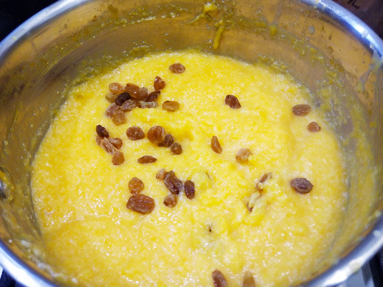 Простой рецепт тыквенной каши с манной крупой и изюмом: Добавляем столовую ложку сахара, щепотку соли и изюм, размешиваем.