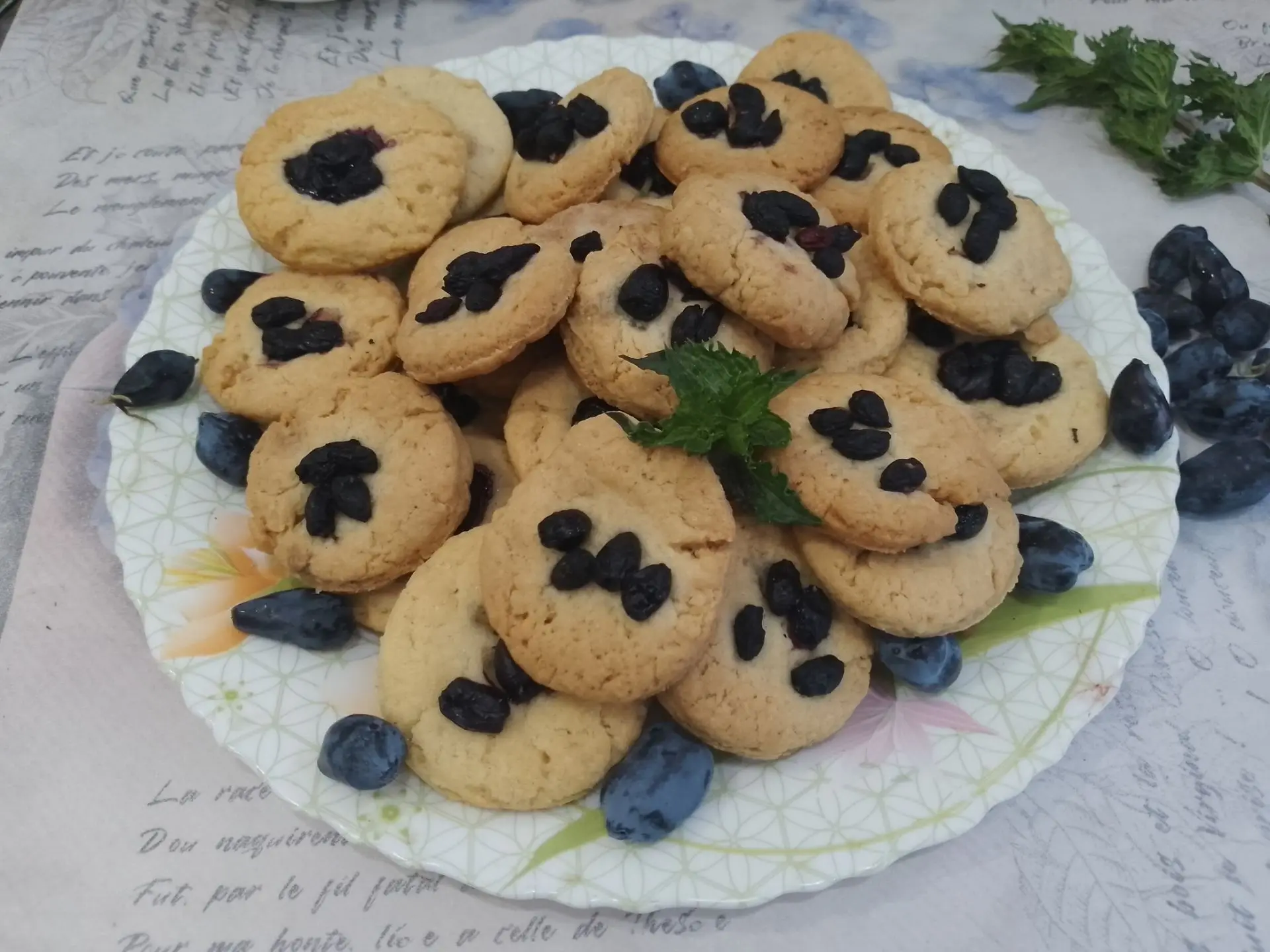 Песочное рассыпчатое печенье с ягодами жимолости: Испеченное печенье по желанию посыпаем сахарной пудрой и складываем на блюдо.