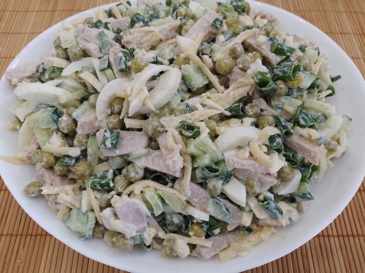 Салат с мясом, зеленым горошком и сухариками: Добавляем соль и майонез по вкусу, перемешиваем и перекладываем в салатницу.