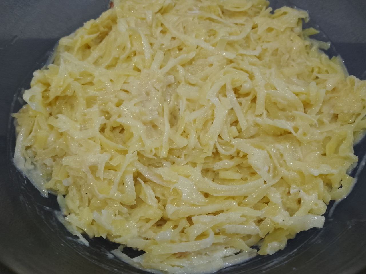 Рулет из тертого картофеля с мясной начинкой, запеченный в духовке: В тертый картофель добавляем муку, яйца, соль, перец и чеснок, тщательно размешиваем.