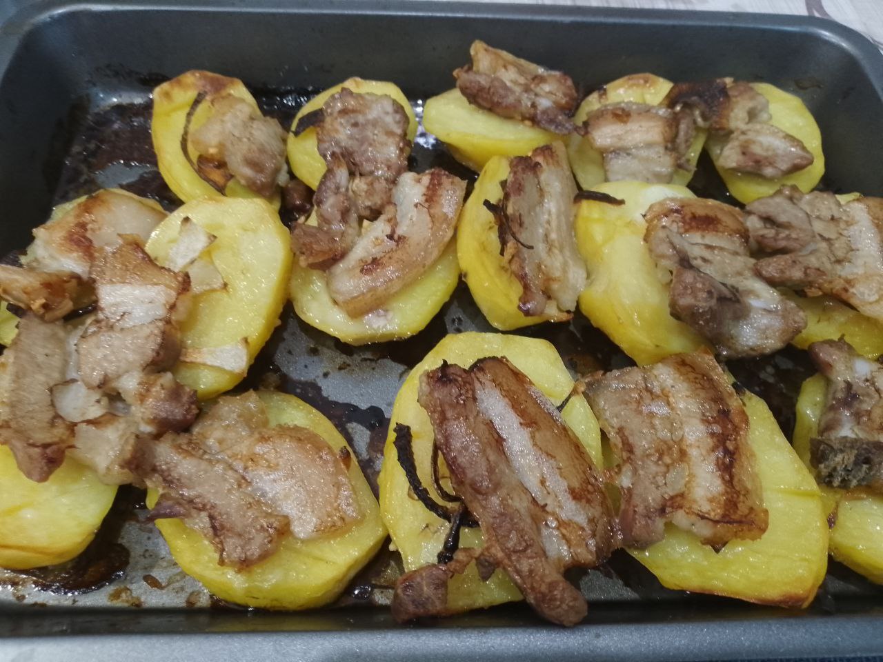 Картофель запеченный в духовке с грудинкой, просто и вкусно: Когда грудинка зарумянится достаем противень из духовки и ломтики грудинкипереворачиваем вместе с луком на