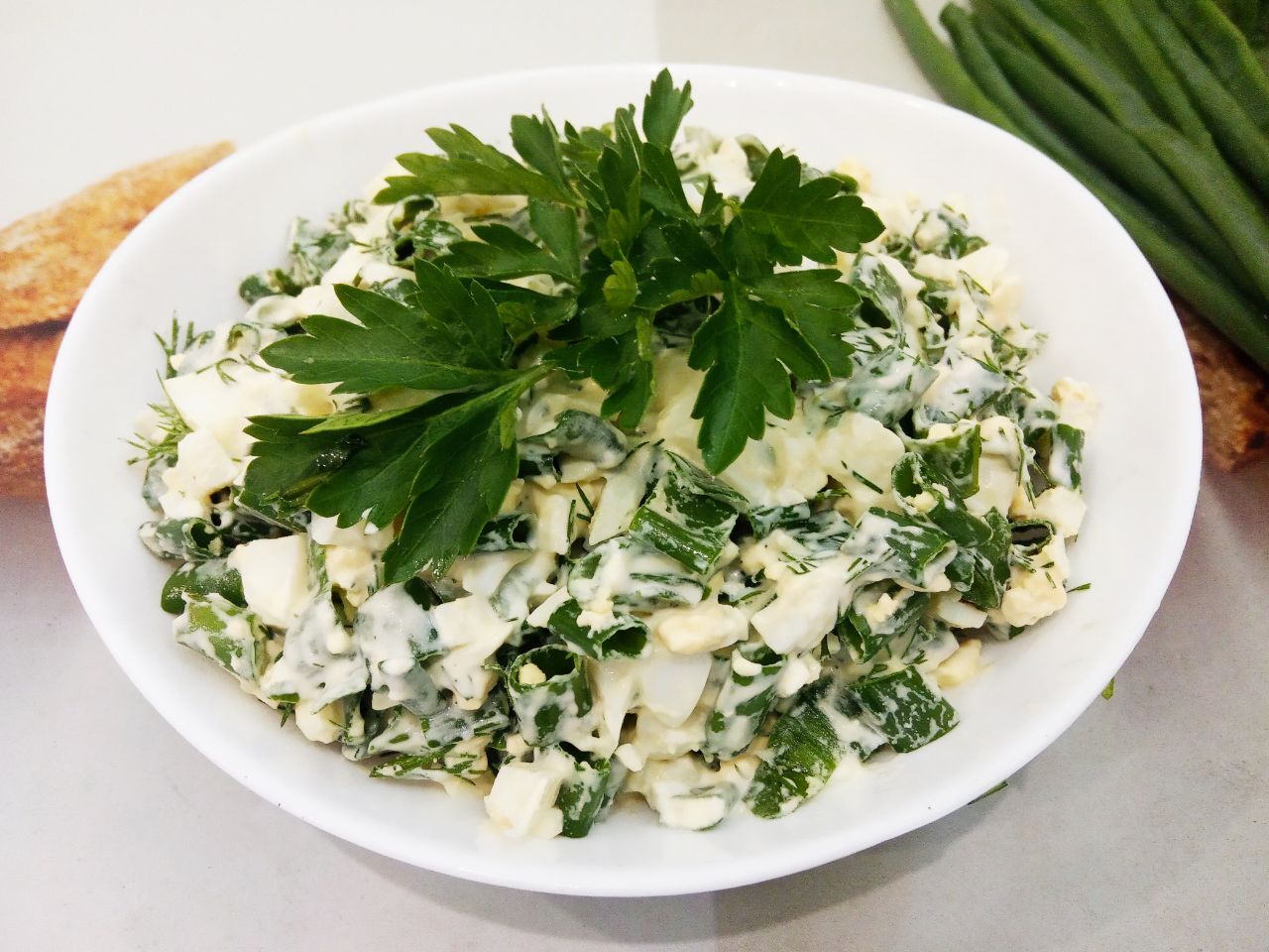 Простой салат с зелёным луком, яйцами и зеленью укропа: Солим салат по вкусу и заправляем майонезом, хорошо размешиваем.