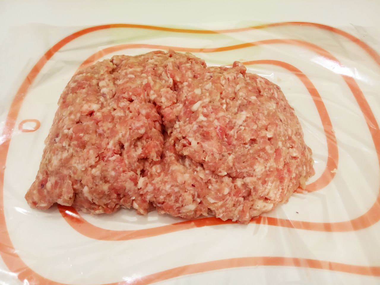 Мясной рулет с сыром в кляре, жареный на сковороде: Затем застилаем пищевую пленку разравниваем котлетную массу равномерно прямоугольником.