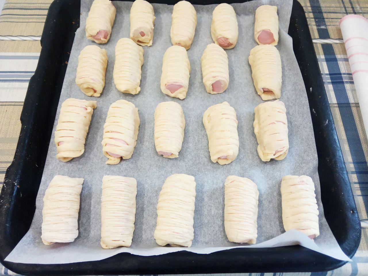 Сосиски в тесте и пампушки в чесночной заливке, вкусно и просто: Противень смазываем растительным маслом или застилаем пергаментом и укладываем сосиски в тесте. Оставляем