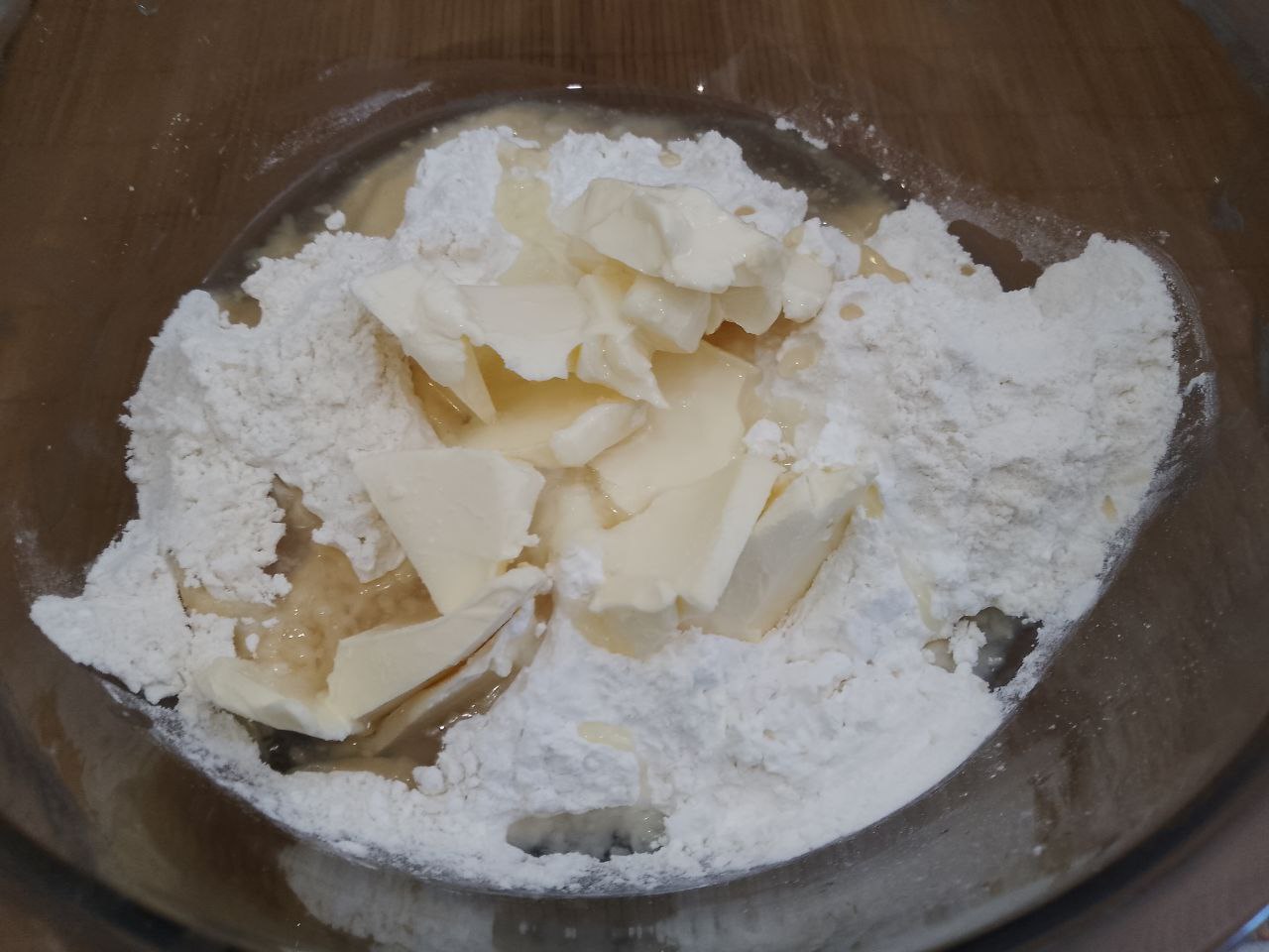 Домашнее печенье с кокосовой стружкой, песочное и рассыпчатое: В сухую смесь вливаем растительное масло и размягченное сливочное масло, растираем в мучную крошку.