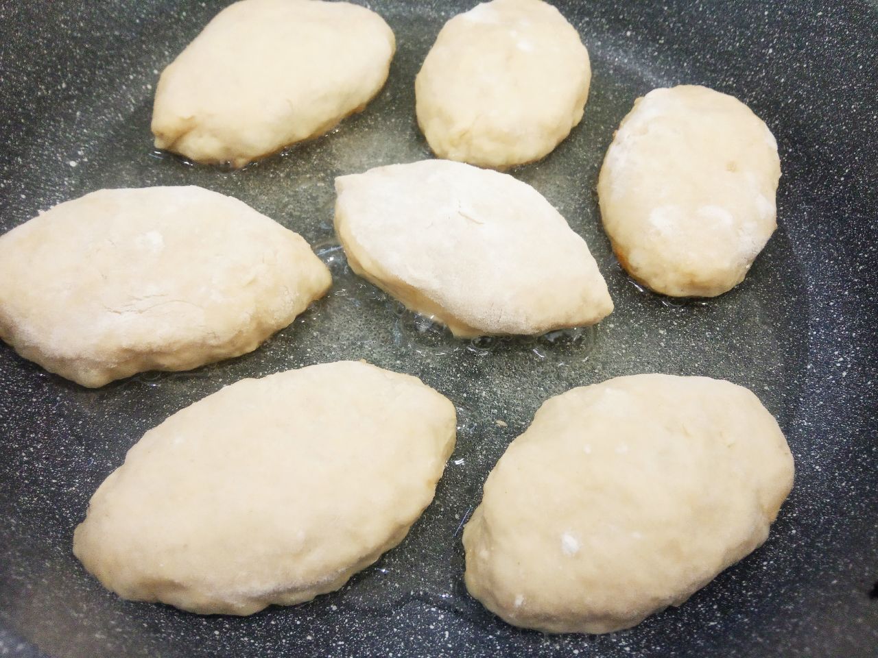 Жареные пирожки из творожного теста, с фаршем и луком, вкусные и аппетитные: Сковороду разогреваем, наливаем растительное масло, доводим до кипения и укладываем пирожки. Растительного