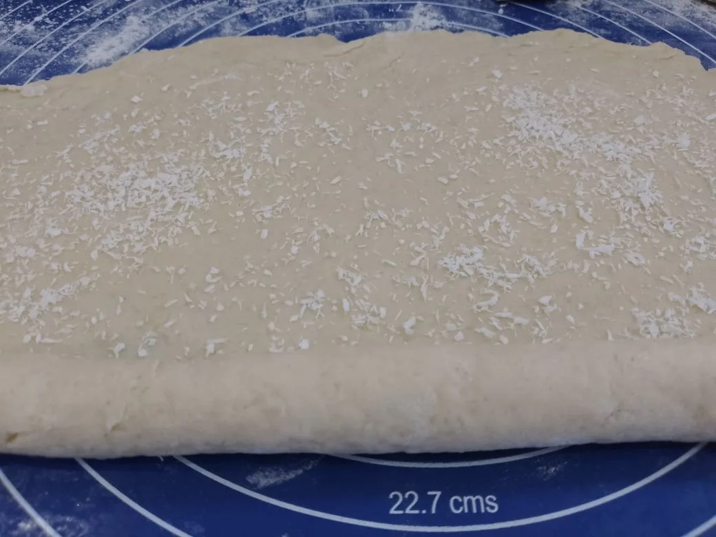 Простой рецепт печенья с кокосовой стружкой, без яиц: Посыпаем кокосовой стружкой и сворачиваем рулетом, шов хорошо придавливаем.