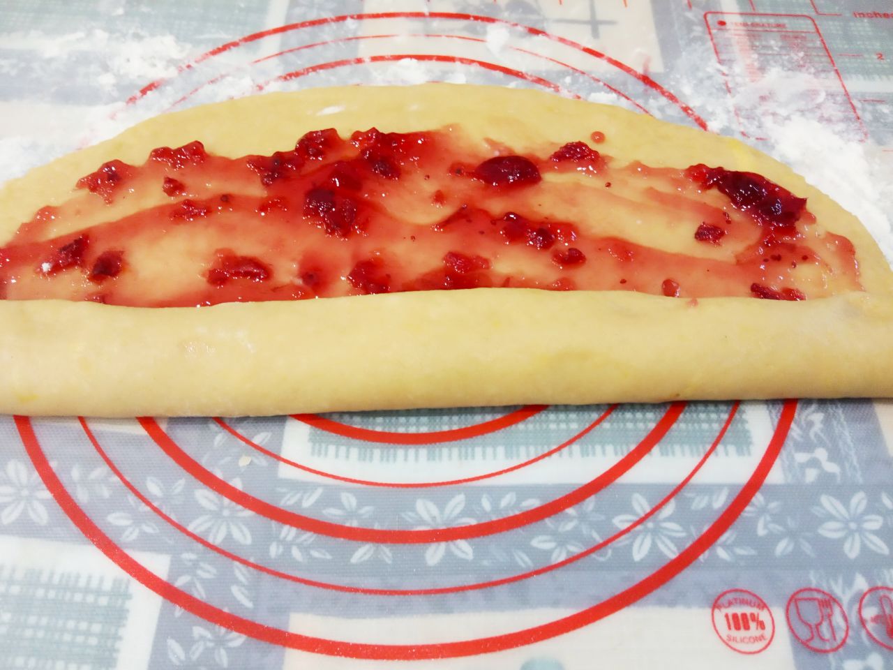 Печенье с джемом и кунжутом подсушенное в духовке: Сворачиваем лист теста рулетом, края придавливаем.