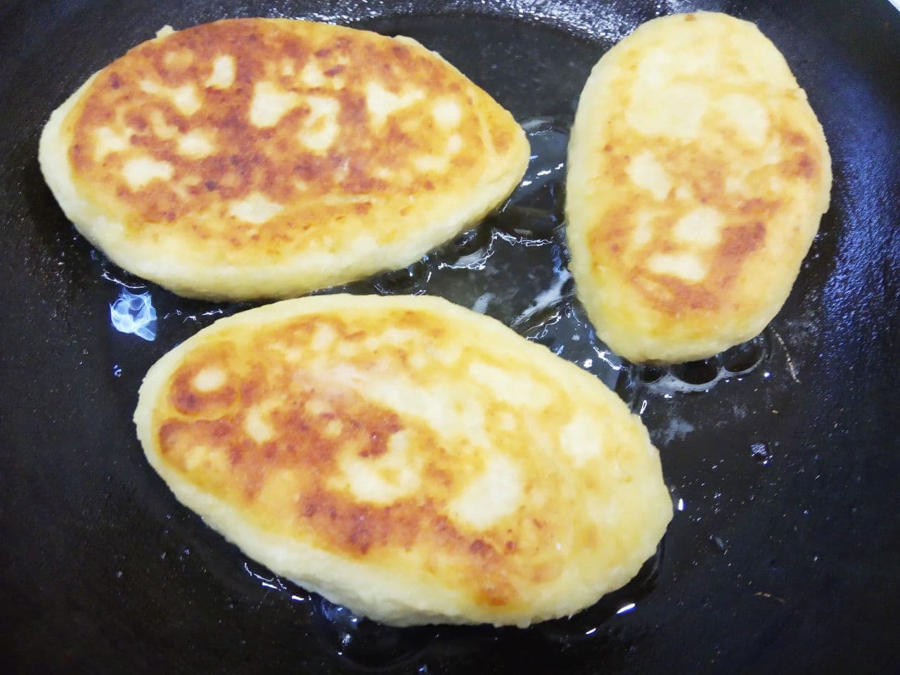 Пирожки с мясной начинкой из картофельного дрожжевого теста, жареные на сковороде: Обжариваем пирожки на небольшом количестве растительного масла на слабом огне с обеих сторон до готовности.