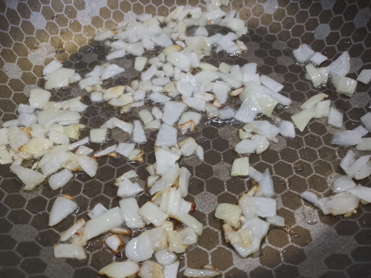 Рулет из тертого картофеля с мясной начинкой, запеченный в духовке: Разогреваем сковороду с растительным маслом, кладем лук и обжариваем до золотистого цвета.
