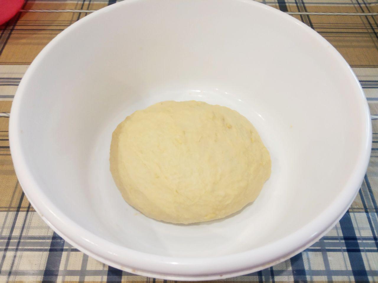 Жареные пончики без яиц с начинкой и с кунжутом: Размягченное сливочное масло кусочками кладем в середину теста и вымешиваем до нежного теста.