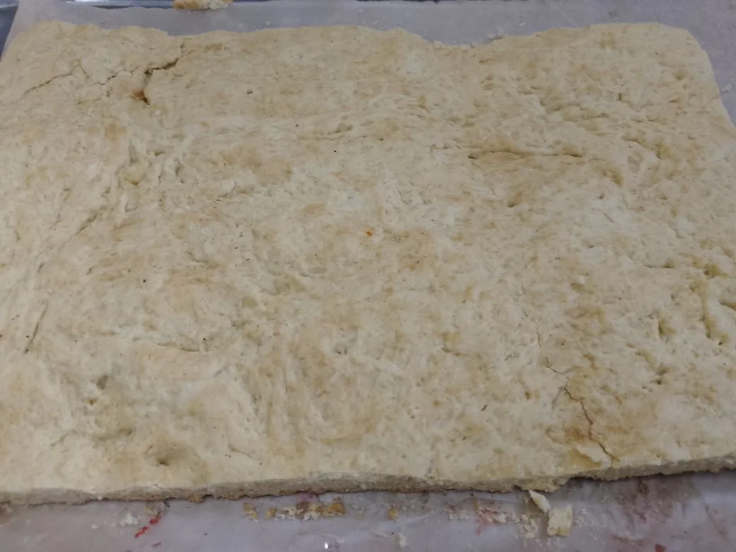 Песочные пирожные с замороженной малиной и в сахарной глазури: Края коржей обрезаем и растираем в крошку. По поверхности коржей распределяем малину и коржи соединяем.