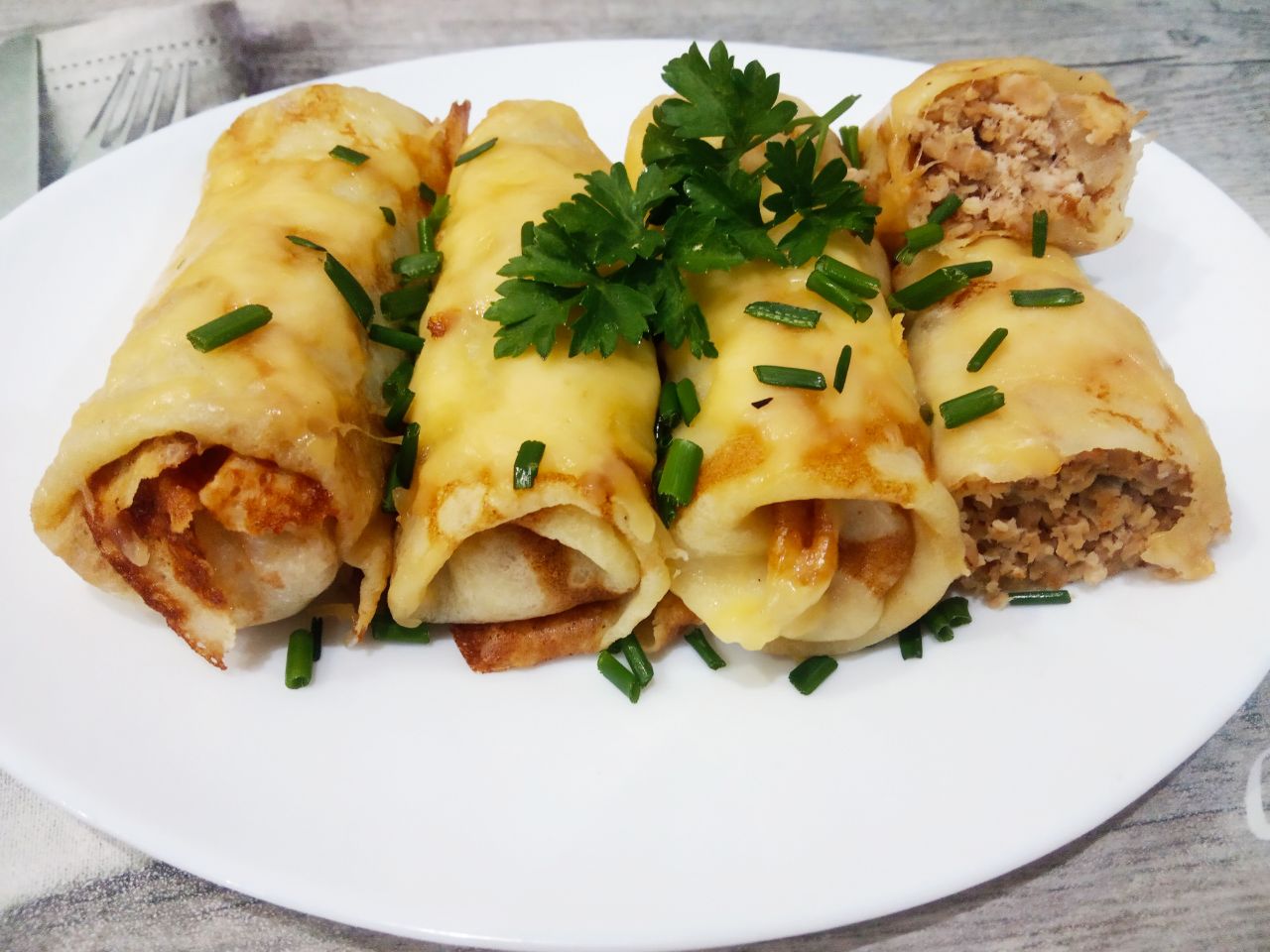 Блинчики с мясом и сыром, запеченные в духовке: Достаем блинчики из духовки, посыпаем зеленью и подаем к столу с соусом, кетчупом или по своему усмотрению.