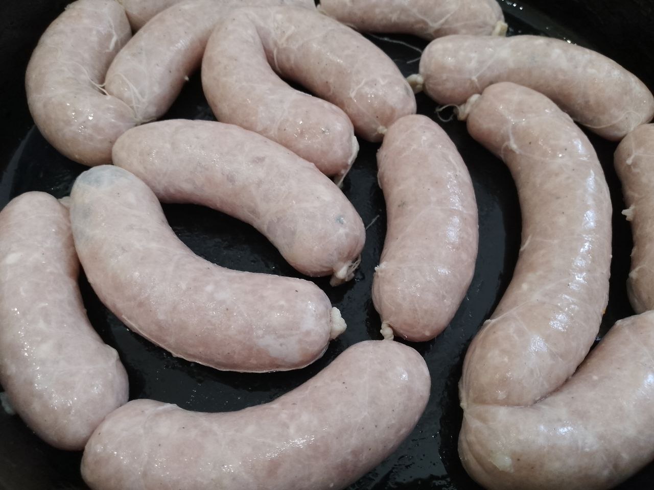 Домашние колбаски из свиного и куриного мяса в натуральной оболочке, запеченные в духовке: Противень смазываем жиром, укладываем колбаски и прокалываем зубочисткой в нескольких местах, чтобы вышел