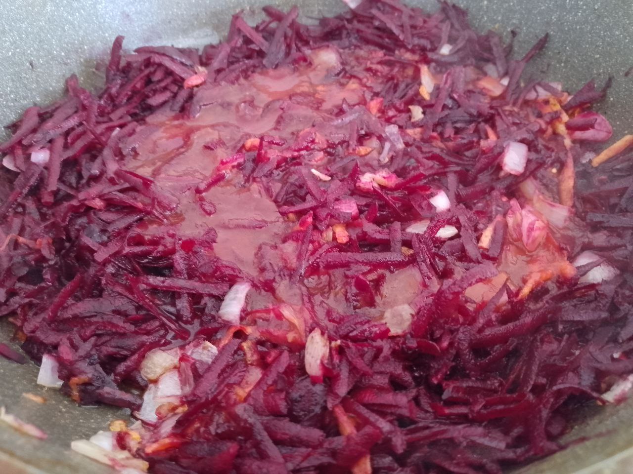 Тушеная свёкла с зеленым горошком и овощами: Добавляем тертую свеклу и тертые помидоры, перемешиваем и обжариваем 5 минут.