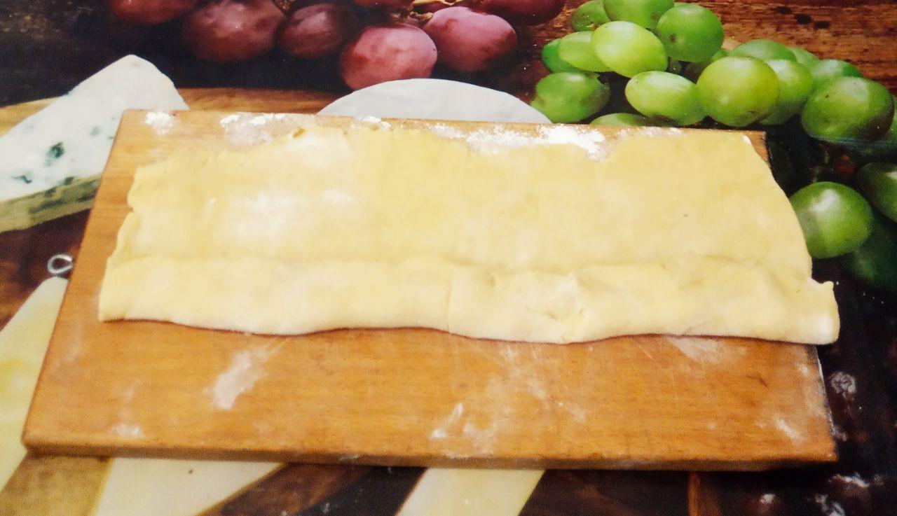 Печенье с творожной начинкой и яблоками: На длинную сторону листа на край выкладываем полоски яблок. Сворачиваем тесто рулетом и разрезаем на