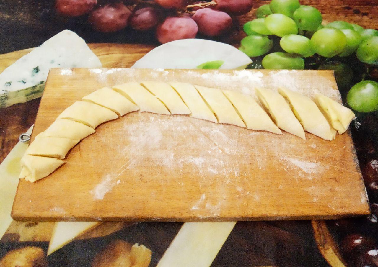 Печенье с творожной начинкой и яблоками: На длинную сторону листа на край выкладываем полоски яблок. Сворачиваем тесто рулетом и разрезаем на