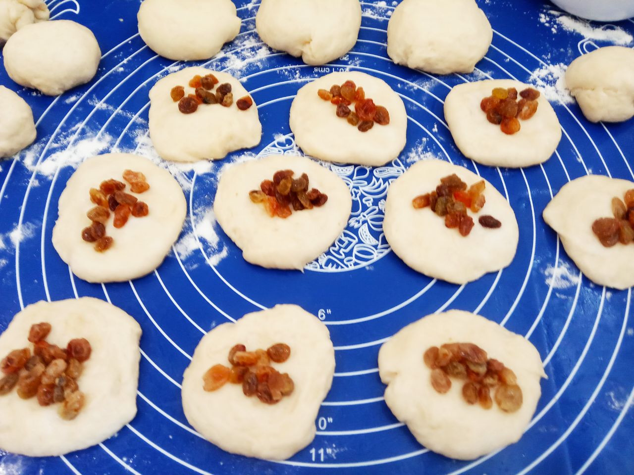 Воздушные и мягкие булочки с изюмом, в сахарной глазури: На середину кружочков кладем изюм.