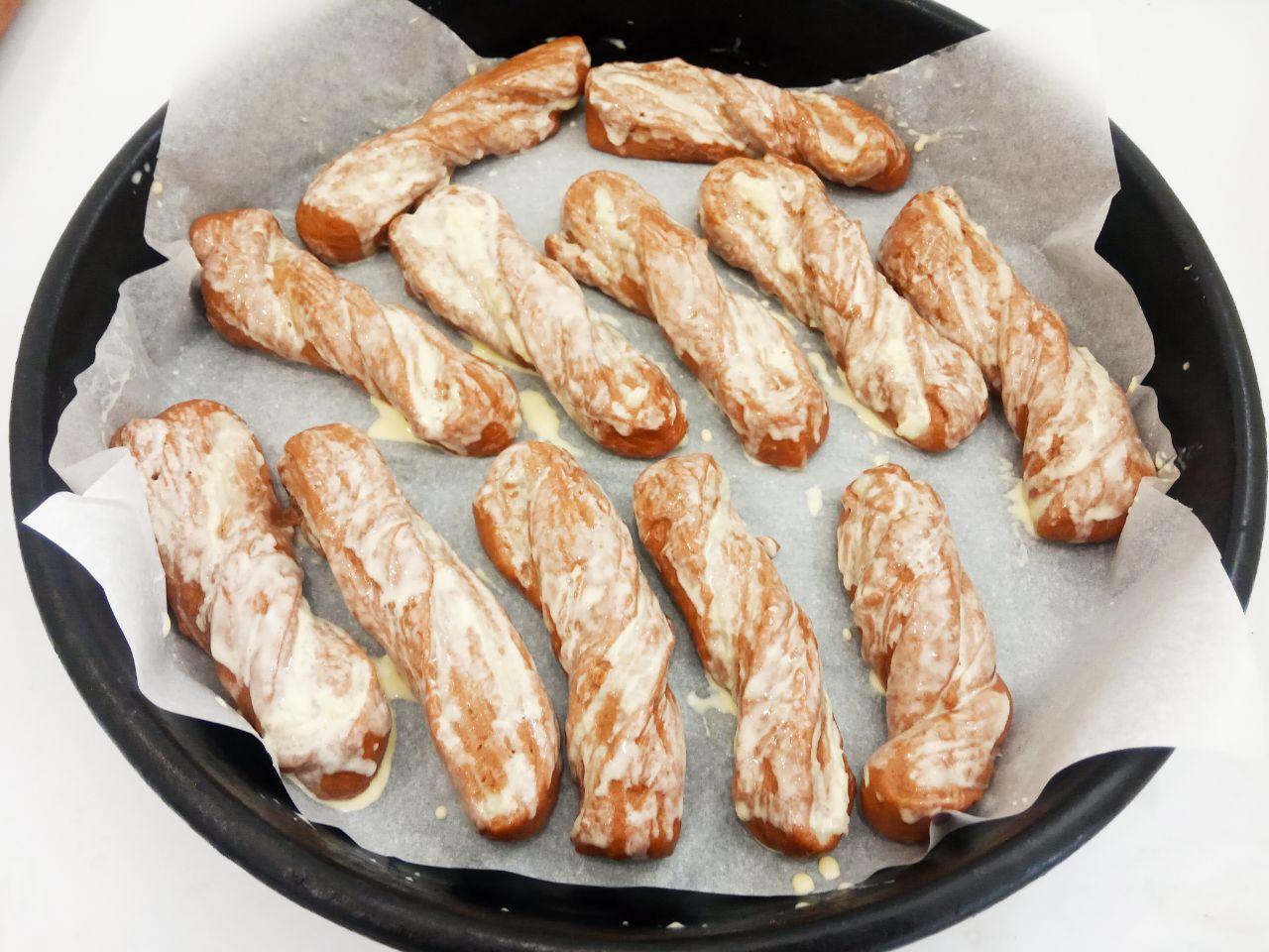 Шоколадные булочки из заварным кремом, нежные и воздушные: Булочки ставим на расстойку на 20 минут. Сметану соединяем с желтком, размешиваем и смазываем булочки.