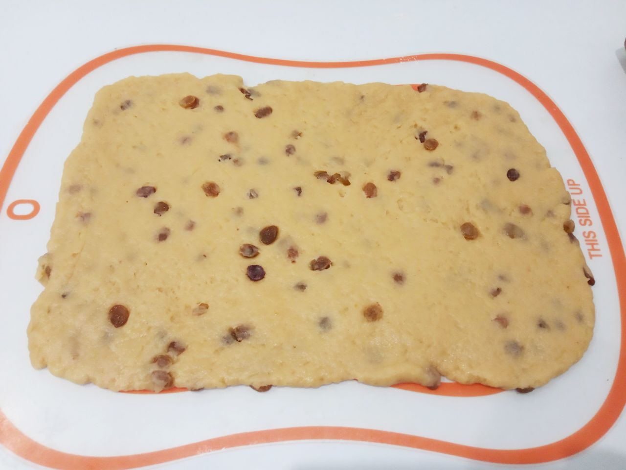 Рассыпчатое печенье с изюмом, на растительном масле: Тесто разделяем на две части, так удобнее формировать печенье. Тесто раскатываем тонким прямоугольным листом.