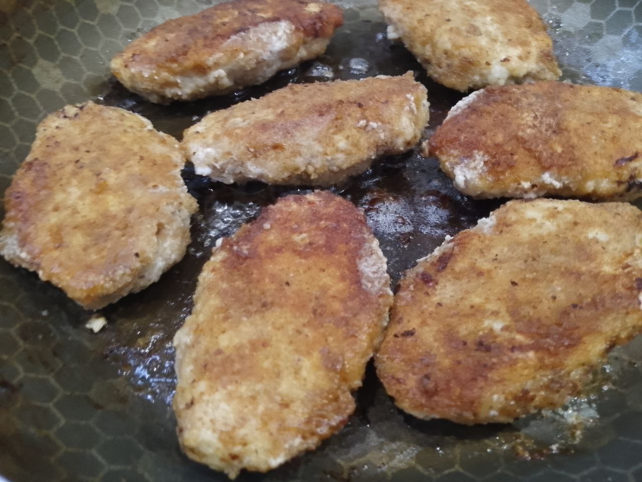 Котлеты из куриного мяса в яичном кляре и панировочных сухарях: Переворачиваем котлеты на другую сторону и продолжаем жарить до полной готовности.