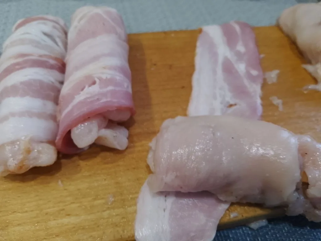 Куриное филе запеченное в беконе, с начинкой из твердого сыра: Я использовала сырокопченый бекон, на полоску бекона кладем рулет и заворачиваем в бекон.