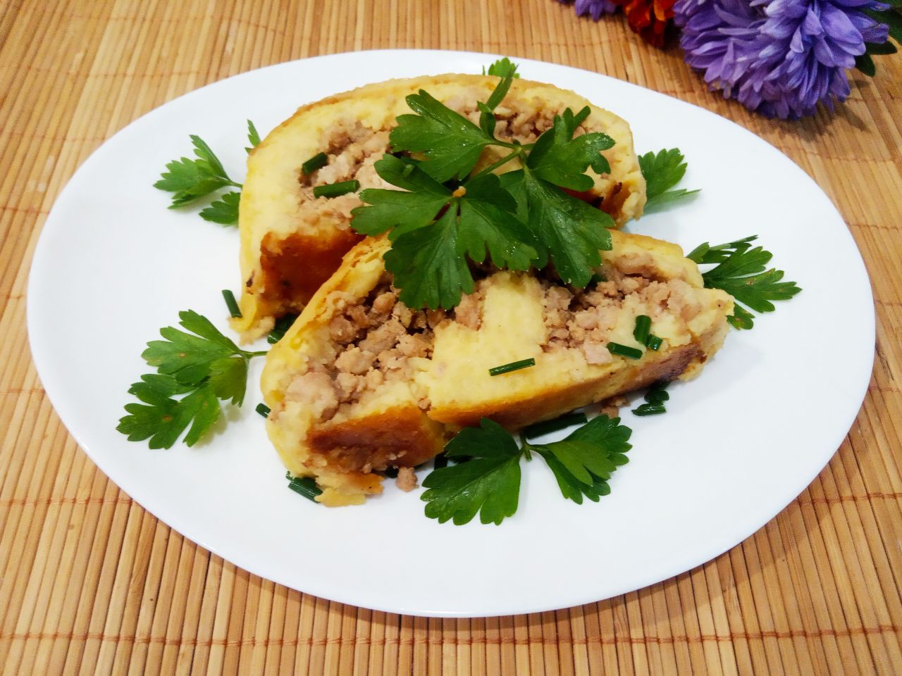 Картофельный рулет с мясной начинкой, запеченный в духовке: Достаем рулет из духовки, разрезаем на порции, посыпаем зеленью и подаем к столу.