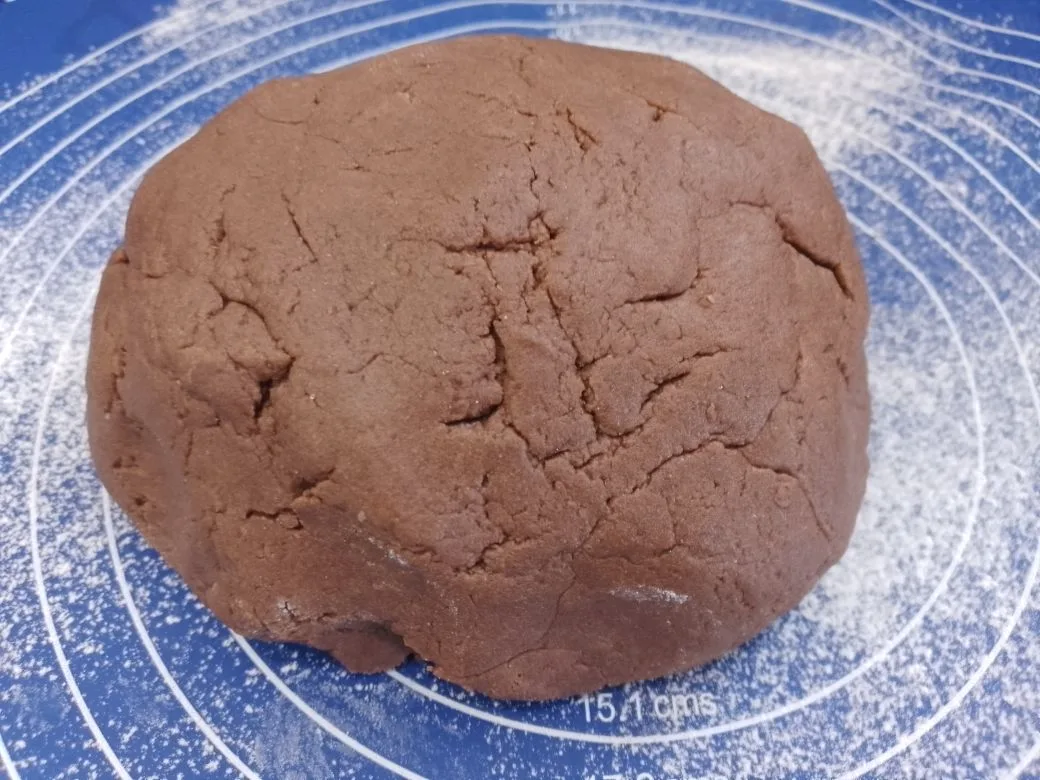 Шоколадное песочное печенье с кунжутом и кокосовой стружкой: Соединяем мучную крошку с яичной смесью, замешиваем мягкое и нежное тесто.