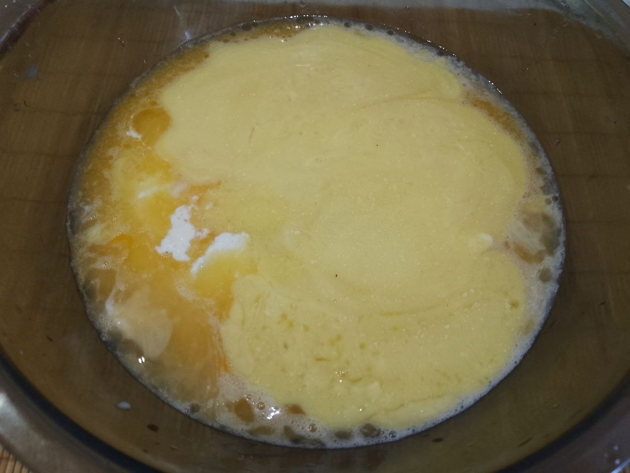 Манный пирог или манник на сметане, просто и вкусно: Выливаем в смесь размешанные яйца и растопленное сливочное масло. Манное тесто хорошо размешиваем.