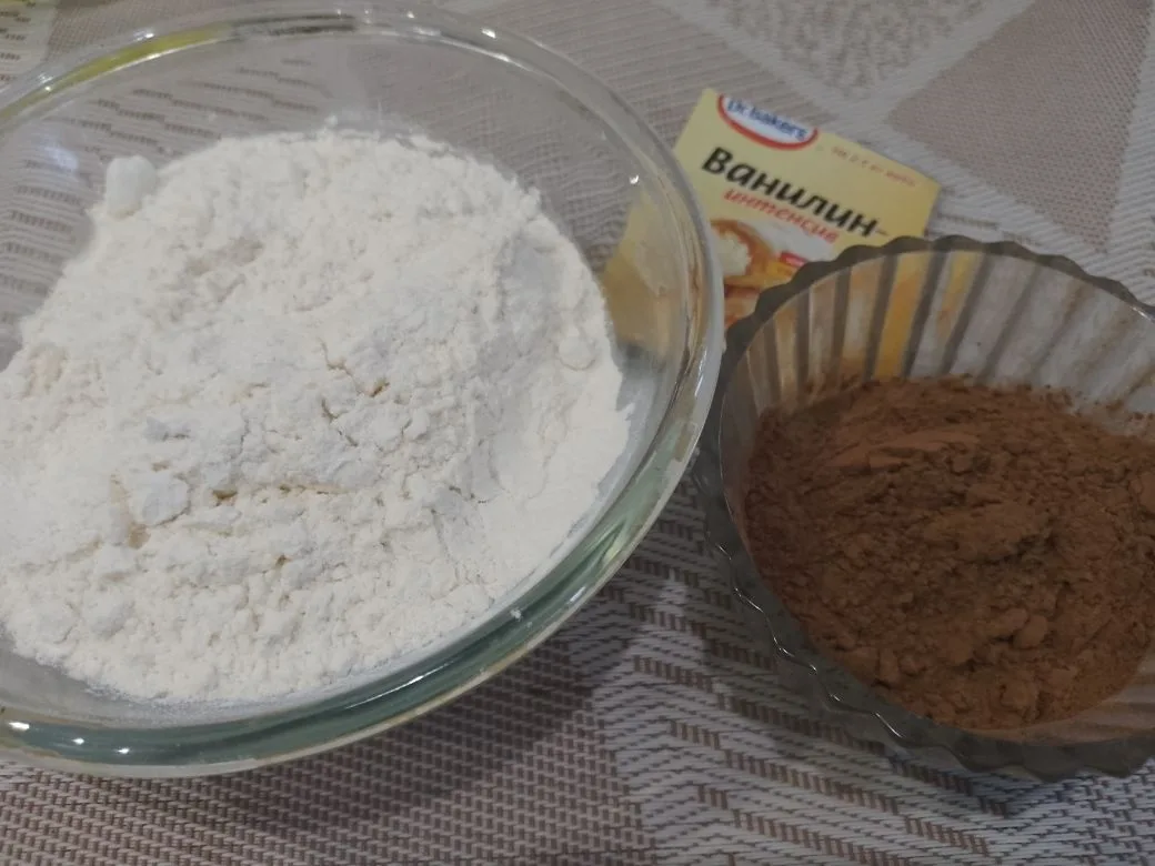 Шоколадное бисквитное печенье с кокосовой стружкой: Муку и какао просеиваем через мелкое сито и высыпаем в смесь. Осторожно перемешиваем снизу вверх.