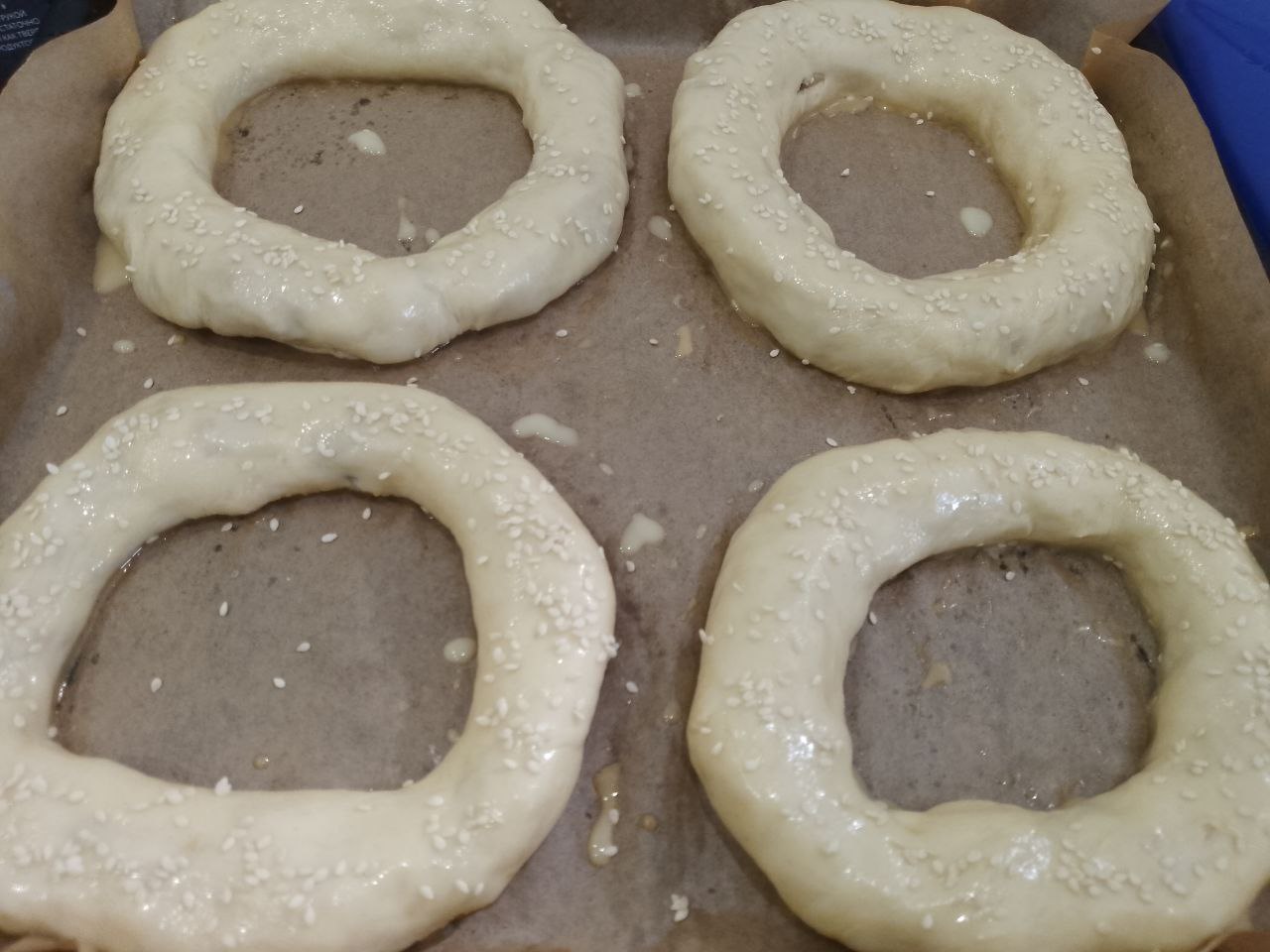 Бублики из дрожжевого теста с мясной начинкой, вкусные и сытные: Желток соединяем с молоком, перемешиваем и смазываем бублики, посыпаем кунжутом.