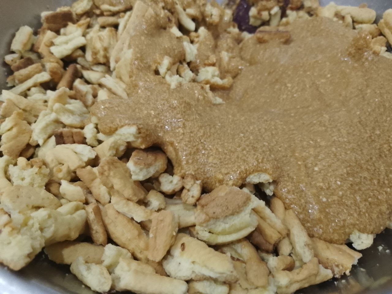 Торт «Муравейник», просто и вкусно: Высыпаем орехи в кусочки печенья и крем, тщательно размешиваем.
