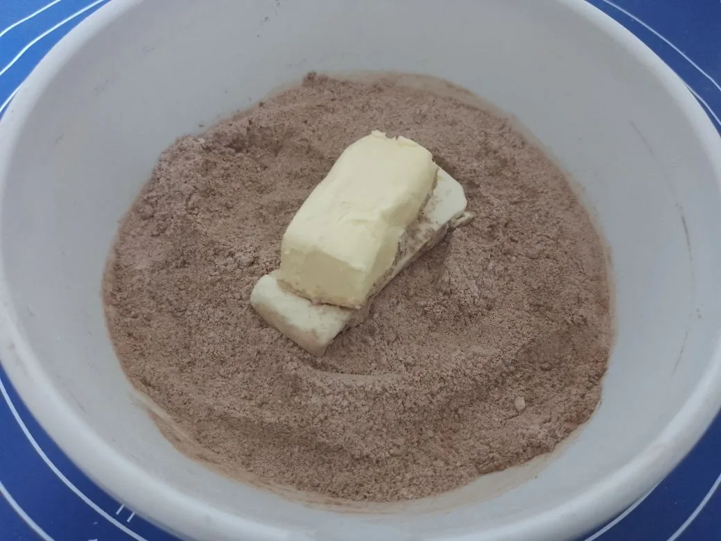 Булочки с начинкой из шоколадной крошки, воздушные и ароматные: Добавляем в сухую смесь размягченное сливочное масло и растираем в крошку.