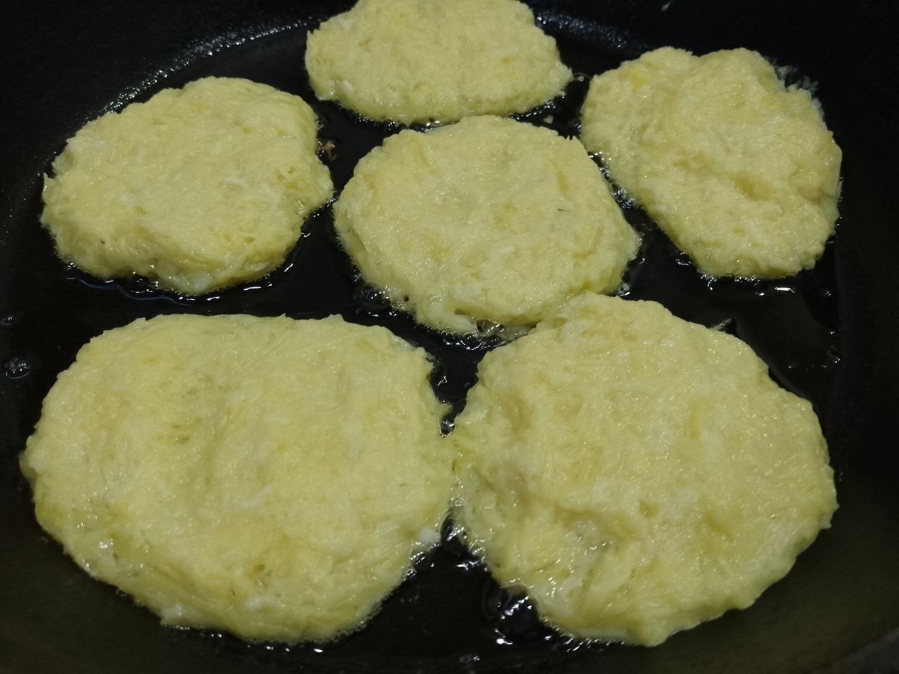 Драники с сыром, яйцом и сметаной: Разогреваем сковороду с растительным маслом и ложкой выкладываем картофельную массу. Накрываем сковороду