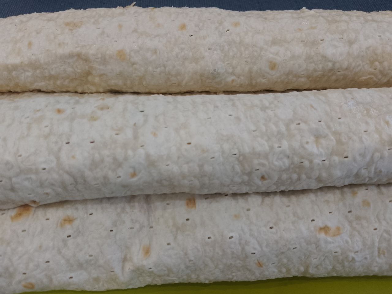 Лаваш с мясной начинкой в кляре, на сковороде: Распределяем ломтики помидоров по начинке и сворачиваем рулетом.